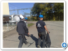 Odchod pracovníků - v pozadí stožáry s kabely vysokého napěti